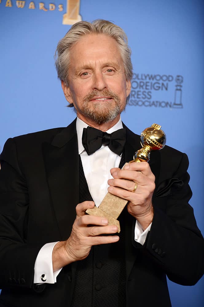 Michael Douglas poses in the press room with the award for best actor in a mini-series or motion picture made for television for `Behind the Candelabra` at the 71st annual Golden Globe Awards.