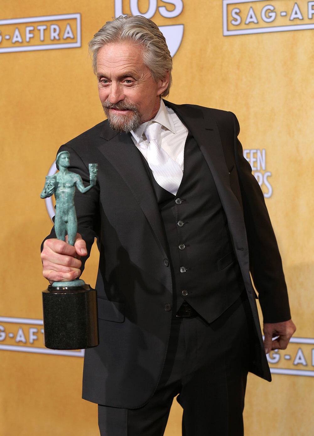 Michael Douglas poses in the press room with the award for outstanding performance by a male actor in a television movie or miniseries for `Behind the Candelabra` at the 20th annual Screen Actors Guild Awards at the Shrine Auditorium.