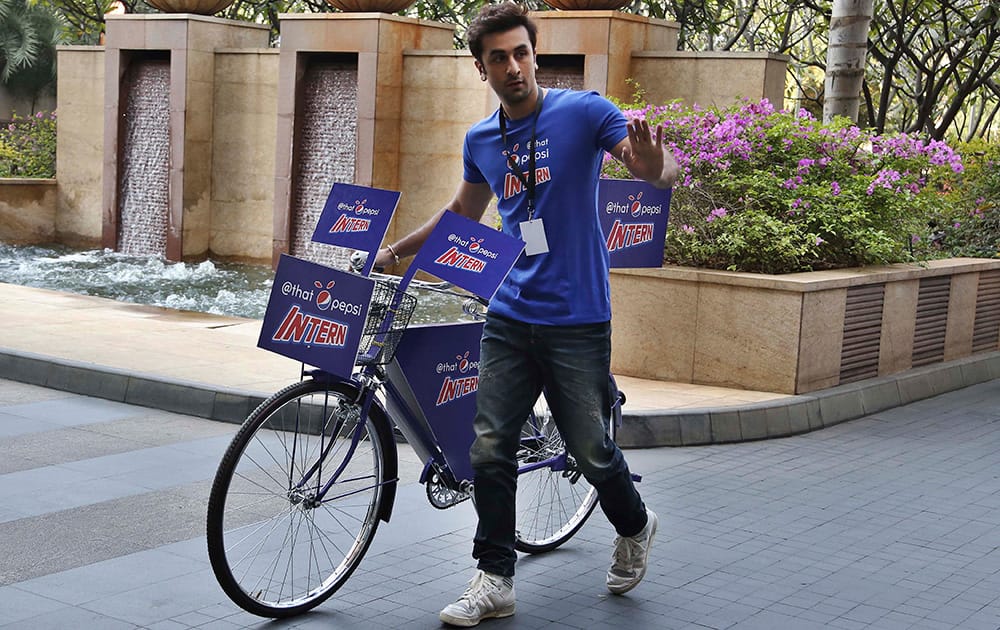 Ranbir Kapoor walks with a bicycle during a promotional event of soft drink major PepsiCo in Bangalore.