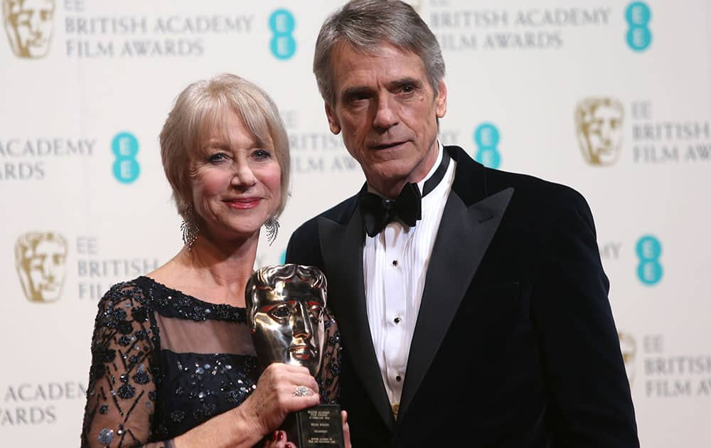 Dame Helen Mirren winner of outstanding contribution and Jeremy Irons poses for photographers in the winners room at the EE British Academy Film Awards held at the Royal Opera House.