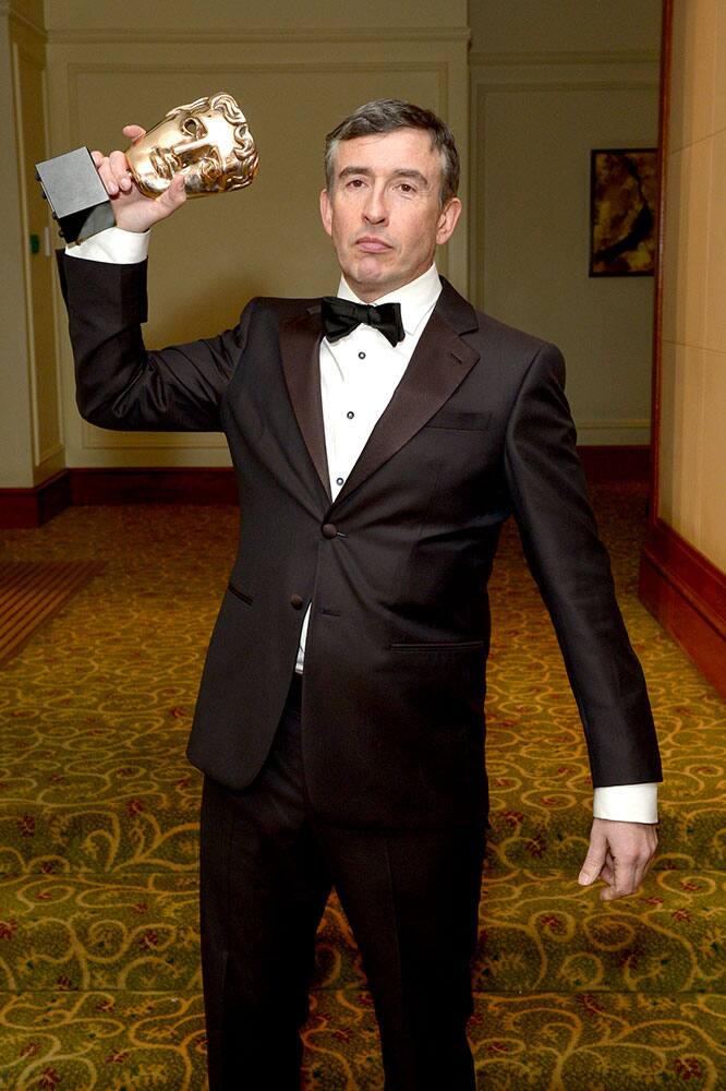 British actor Steve Coogan, winner of the Best Adapted Screenplay award for the movie Philomena, poses with his award as he arrives at the EE British Academy Film Awards Official After Party at the Grosvenor House Hotel.