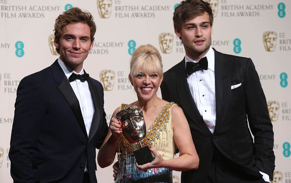 From left, Sam Claflin, Catherine Martin, winner of best costume design and Douglas Booth pose for photographers in the winners room at the EE British Academy Film Awards held at the Royal Opera House in London. 