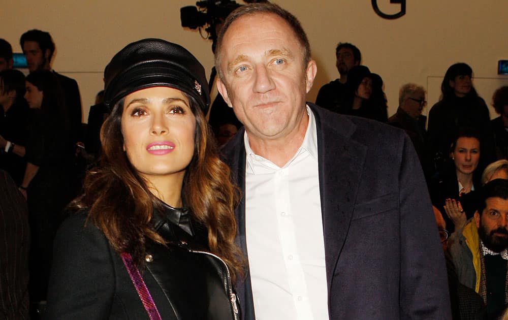 Mexican actress Salma Hayek, left, poses with her husband François-Henri Pinault, of France, prior to the start of the Gucci women's Fall-Winter 2014-15 collection, part of the Milan Fashion Week.