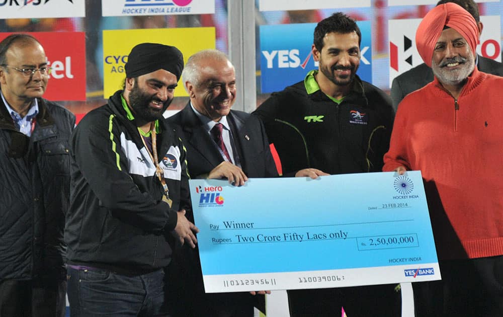 Actor and Co-owner of Delhi Waveriders John Abraham receives cheque after winning the HIL match against Japee Punjab Warriors in Ranchi.