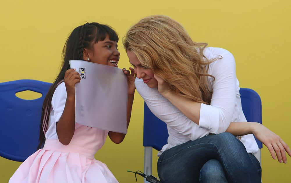 A girl talks to Colombia's pop star Shakira at a the inauguration of a school funded by her foundation `Barefeet` in the neighborhood Loma del Peye in Cartagena, Colombia.