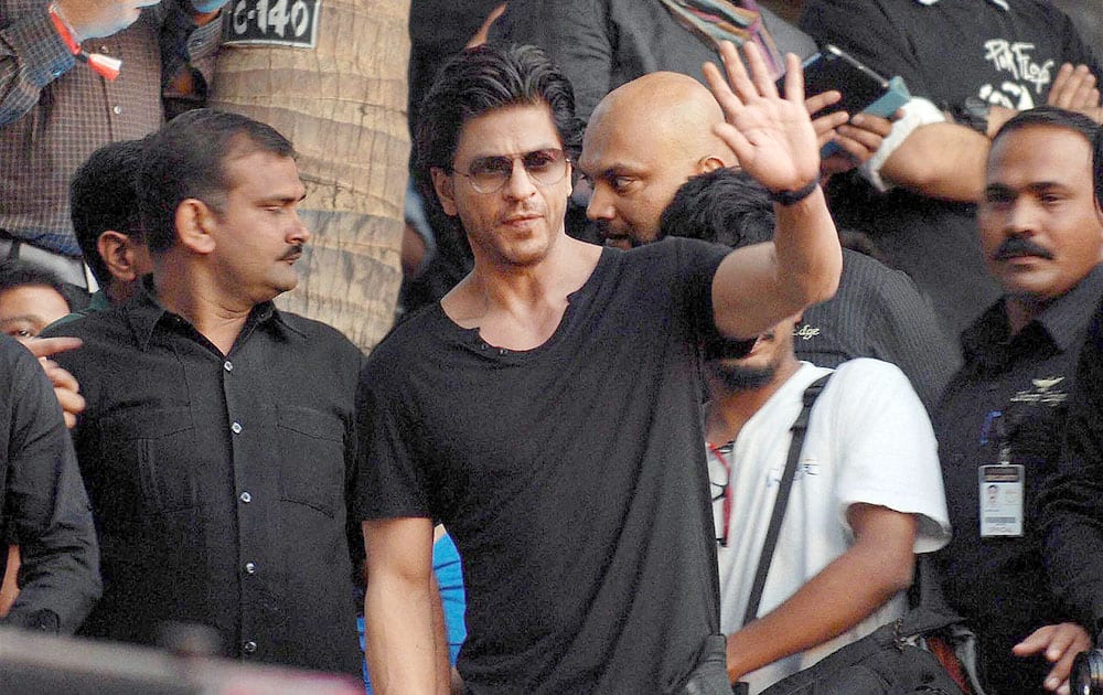 Bollywood actor Shahrukh Khan waves hands at the audience during an event in Mumbai.