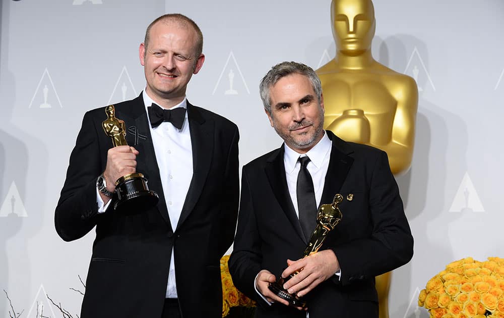 Alfonso Cuaron and Mark Sanger pose in the press room with the award for best film editing for 'Gravity' during the Oscars at the Dolby Theatre, in Los Angeles.