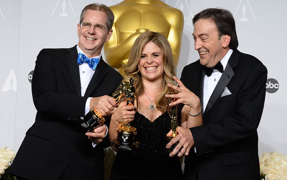 Chris Buck, Jennifer Lee and Peter Del Vecho pose in the press room with the award for Best animated feature film of the year for 'Frozen' during the Oscars at the Dolby Theatre.