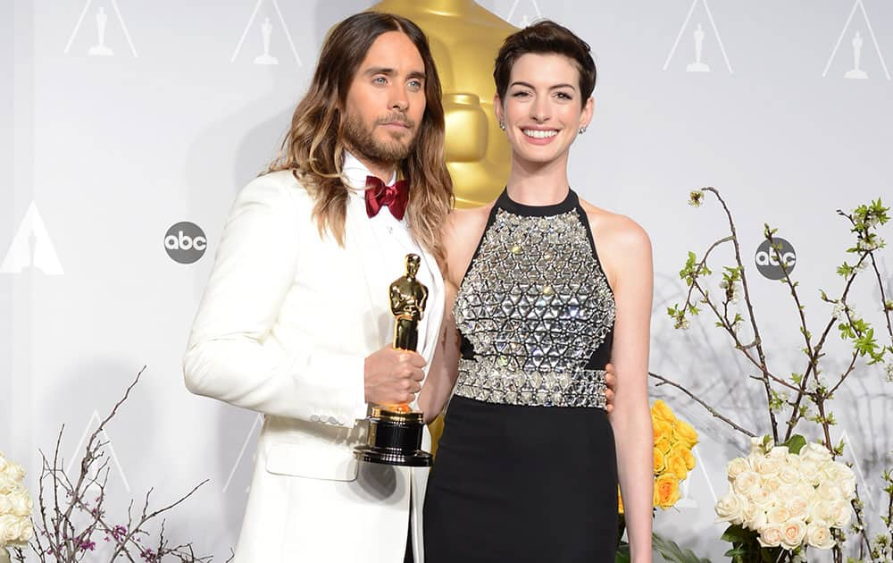 Jared Leto, poses in the press room with his award for best supporting actor for his role in 'Dallas Buyers Club' with Anne Hathaway during the Oscars at the Dolby Theatre, in Los Angeles.