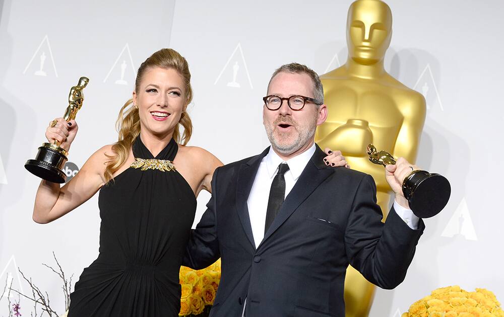 Caitrin Rogers and Morgan Neville pose in the press room with the award for best documentary feature of the year for '20 Feet from Stardom' during the Oscars at the Dolby Theatre.