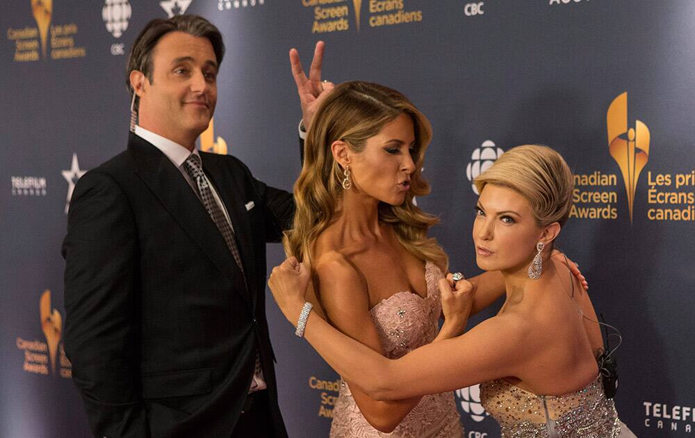 Ben Mulroney, left, and Dina Pugliese, center, and Cheryl Hickey pose for photos as they arrive at the Canadian Screen Awards in Toronto.