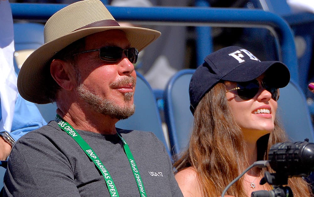 Oracle CEO Larry Ellison and his girlfriend, Ukranian actress Nikita Kahn, watch Roger Federer, of Switzerland, and Dmitry Tursunov, of Russia, competet during a third round match at the BNP Paribas Open tennis tournament.