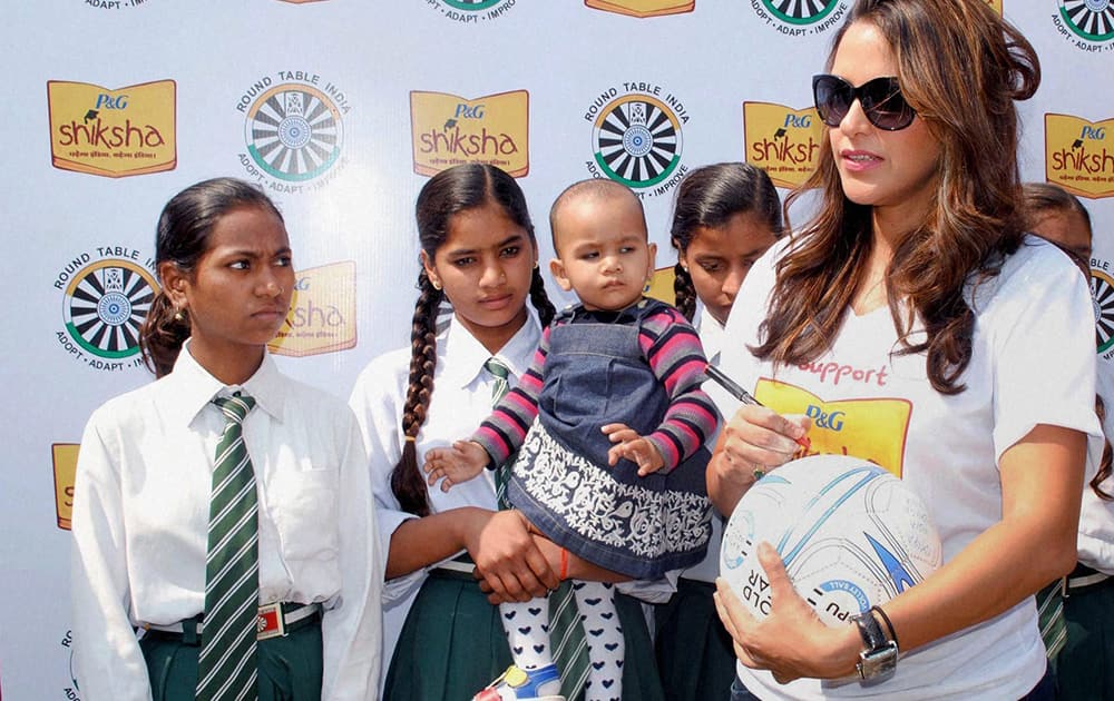 Neha Dhupia with school girls at a public meeting in Kanpur.