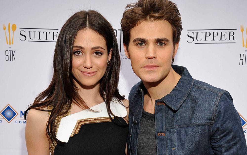 Actress Emmy Rossum, left, poses with actor Paul Wesley on the red carpet during the 