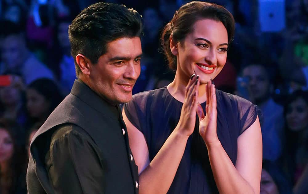  Sonakshi Sinha, right, displays a creation by designer Manish Malhotra, left, during the opening day of Lakme Fashion Week.