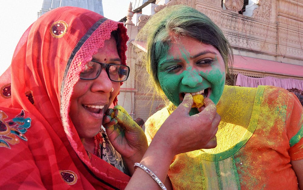 Women enjoying ladoo during Latthmaar holi celebration in Barsana near Mathura.