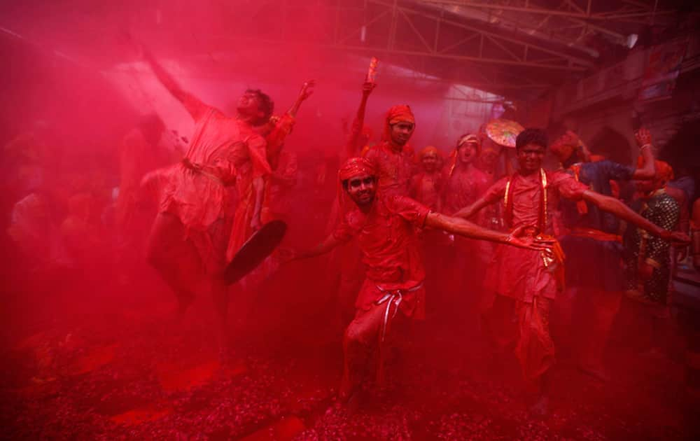 Men from the village of Nandgaon throw colored powder on others as they play holi at the Ladali or Radha temple, before the procession for the Lathmar Holi festival, the legendary hometown of Radha, consort of Hindu God Krishna, in Barsana.