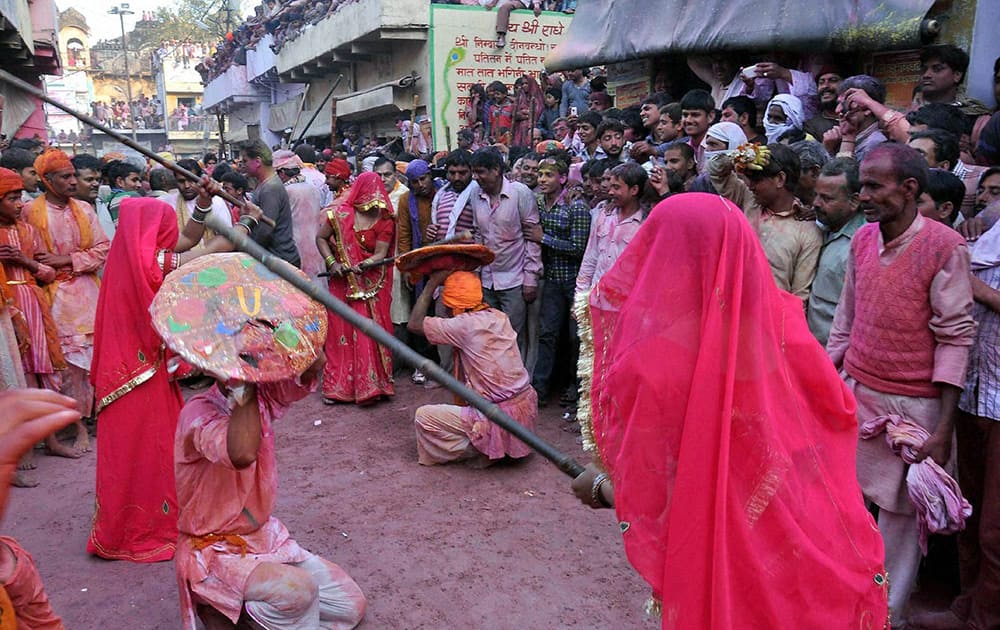 Barsana women beating up men of Nandgaon with sticks during Latthmaar Holi celebration in Mathura.