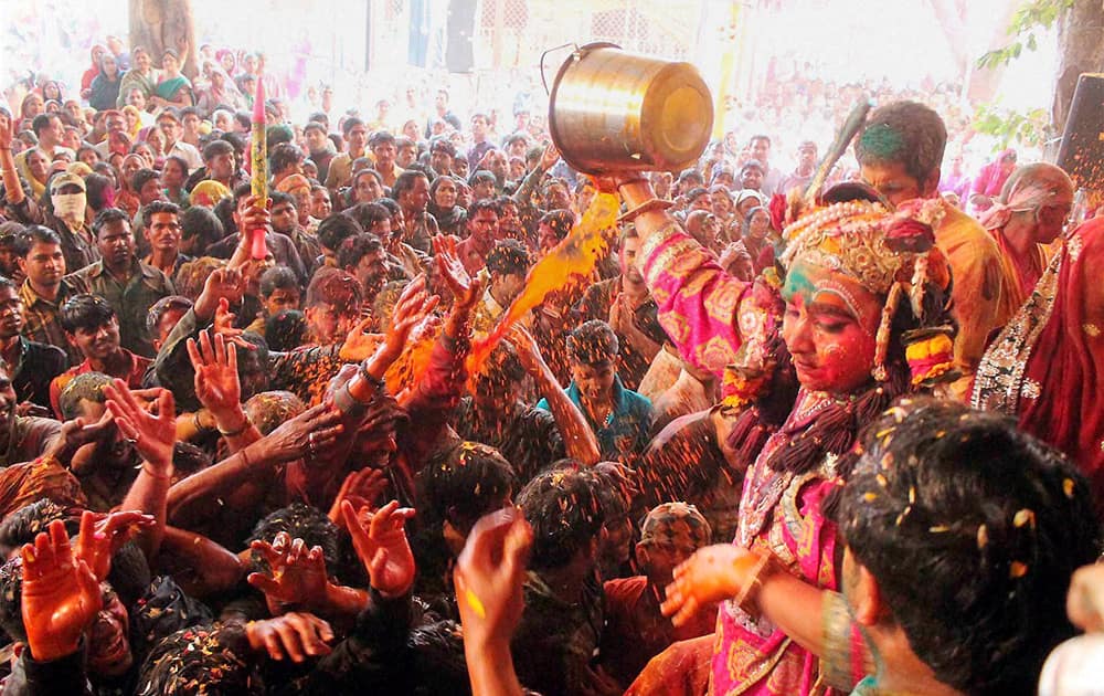 Devotees celebrate Holi at Raman Reti in Mathura.