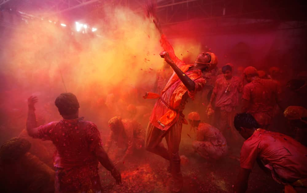 Hindu men from the village of Nandgaon throw colored powder on others as they play holi at the Ladali or Radha temple before the procession for the Lathmar Holi festival, the legendary hometown of Radha, consort of Hindu God Krishna, in Barsana.