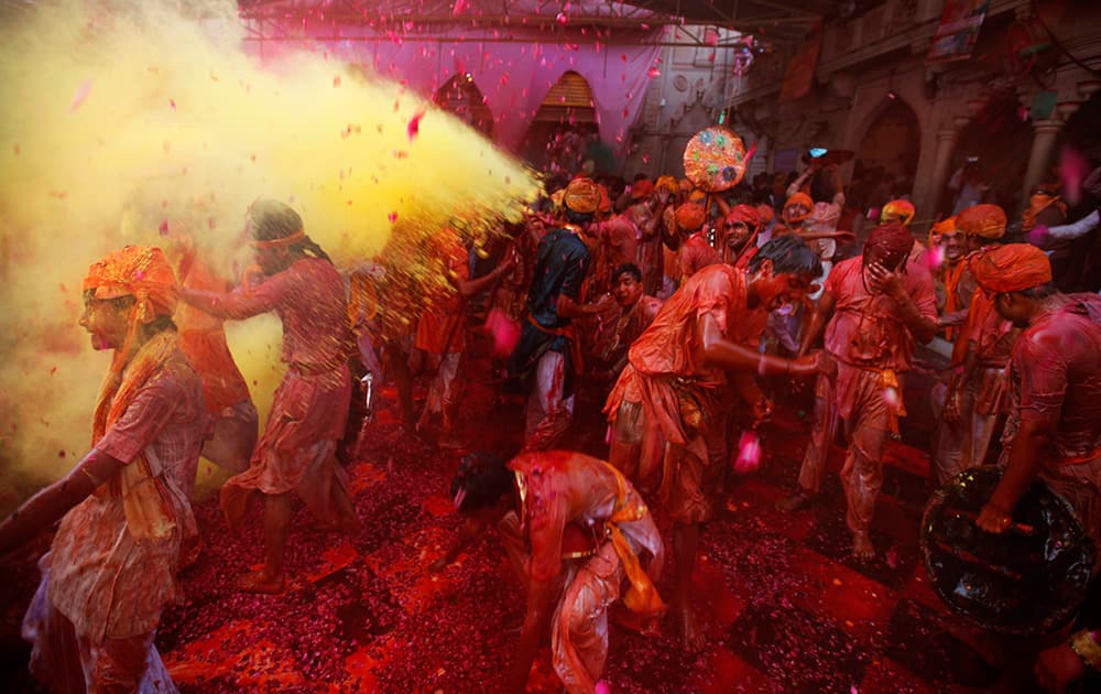 Hindu men from the village of Nandgaon throw colored powder on others as they play holi at the Ladali or Radha temple before the procession for the Lathmar Holi festival, the legendary hometown of Radha, consort of Hindu God Krishna, in Barsana.