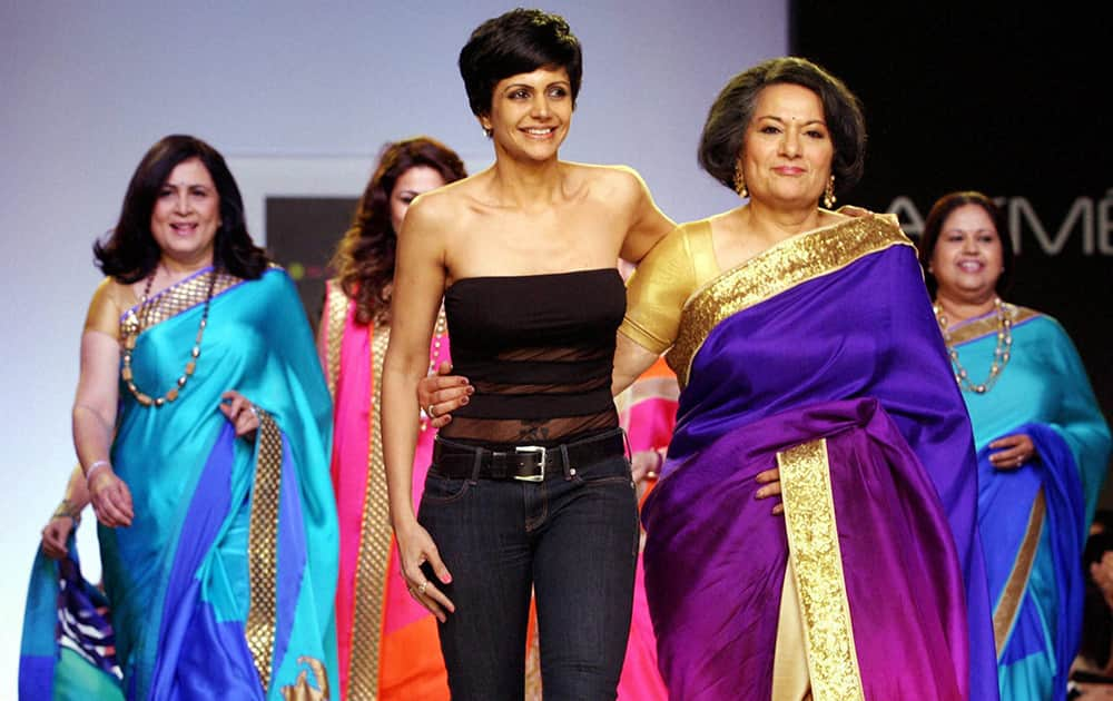 Anchor-actress-designer Mandira Bedi flanked by her mother Geta Bedi (R) walks the ramp during her first fashion show during the Lakme Fashion Week 2014 in Mumbai.