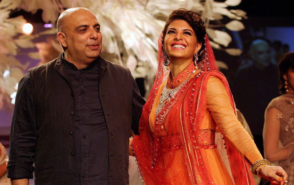 Jacqueline Fernandez alongwith designer Tarun Tahiliani walks the ramp displaying his collection on the first day of the Lakme Fashion Week 2014 in Mumbai.