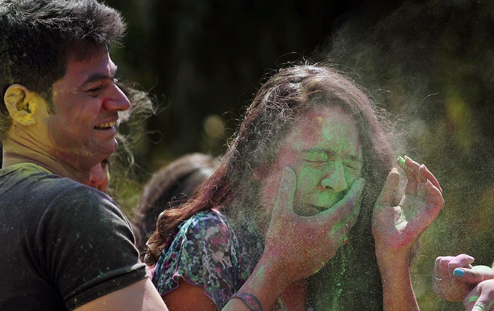 A man smears color on the face of a girl as they celebrate the Holi festival in Ahmadabad.