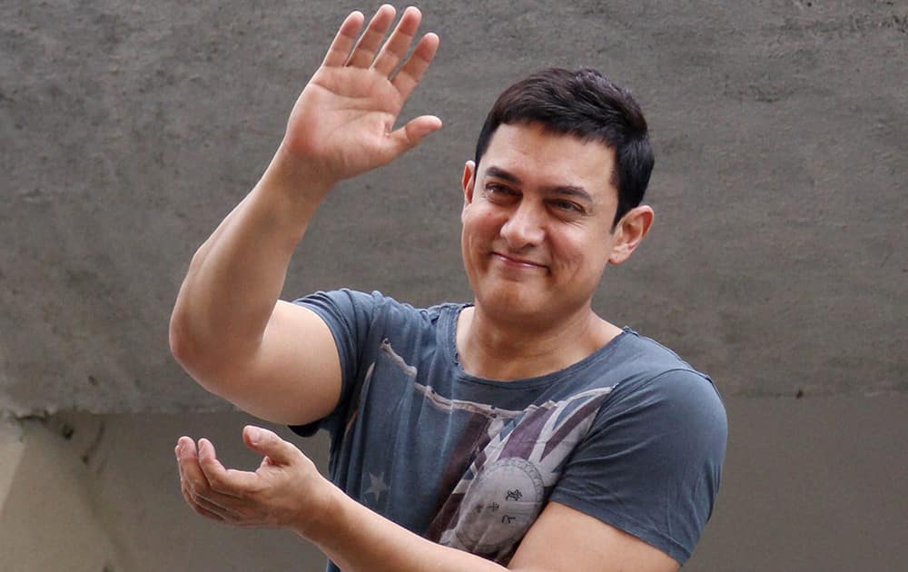 Amir Khan waves at his fans gathered outside his house to wish the actor on his 49th birthday in Mumbai.