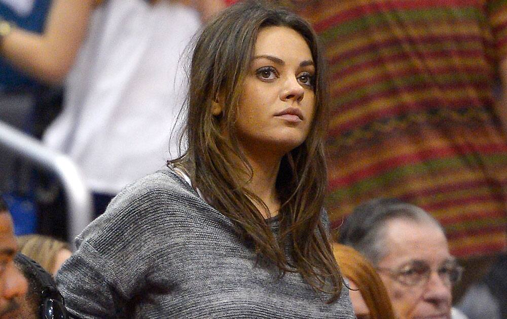 Actress Mila Kunis gets up to leave after watching the Los Angeles Clippers play the Detroit Pistons during the second half of an NBA basketball game, in Los Angeles. 