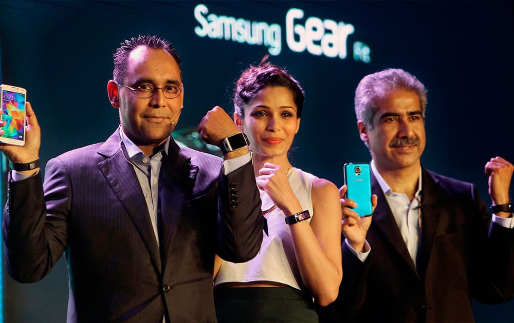 Vinee Taneja, Country Head, IT & Mobile, Samsung India and Manu Sharma, Director, Mobile, Samsung India with actress Freida Pinto display Samsung Galaxy S5 smartphone during its launch in New Delhi.