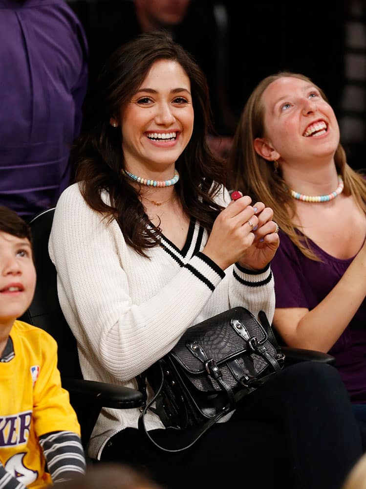 Actress Emmy Rossum sits courtside at the NBA basketball game between the Portland Trail Blazers and the Los Angeles Lakers in Los Angeles.