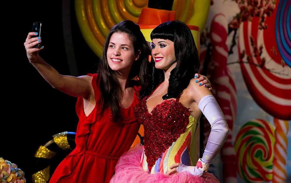 Fan Tansy Ratcliffe-James poses with the newly unveiled wax figure of American recording artist Katy Perry, by studio artist Caryn Bloom, at Madame Tussauds, London. The figure, which is visiting from Madame Tussauds Sydney, will be on display over the Easter period. London.