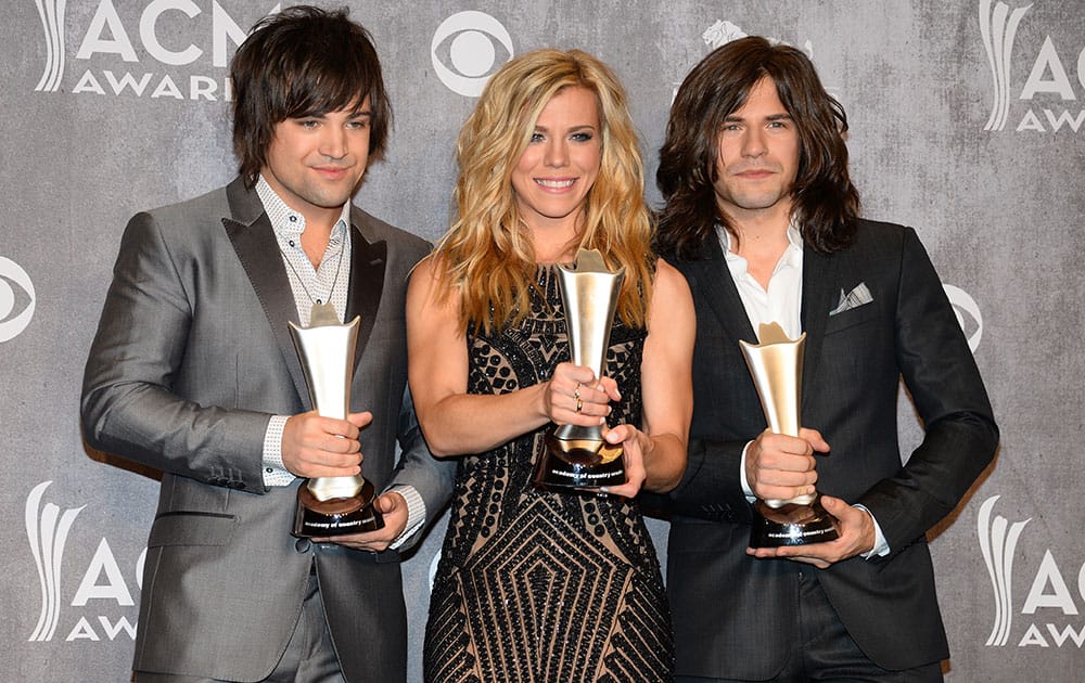 Dave Haywood, and from left, Hillary Scott and Charles Kelley, of the musical group The Band Perry, pose in the press room with the award for vocal group of the year at the 49th annual Academy of Country Music Awards at the MGM Grand Garden Arena in Las Vegas. 