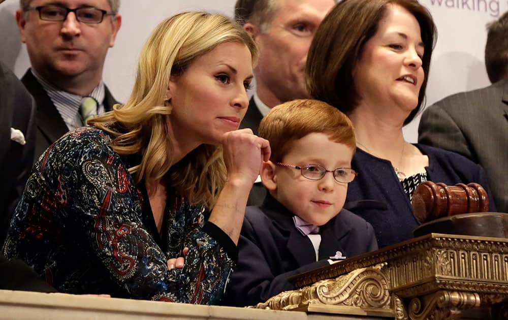 Supermodel Niki Taylor and March of Dimes 2014 National Ambassador Aidan Lamothe watch floor activity from the podium before ringing the New York Stock Exchange closing bell.