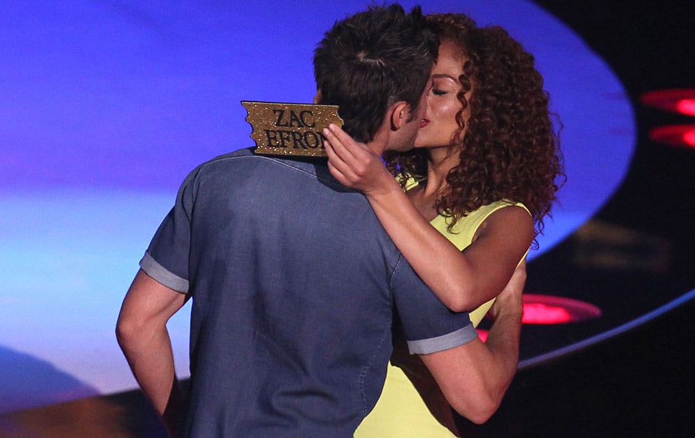 Zac Efron, left, kisses a contestant on stage at the MTV Movie Awards at Nokia Theatre in Los Angeles.