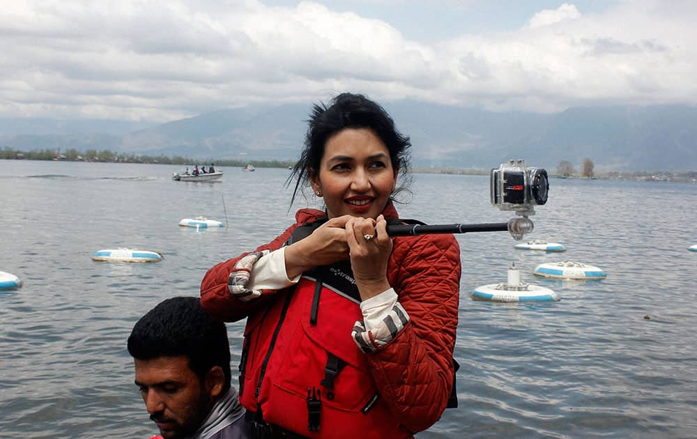 Bollywood actress and singer Deepti Bhatnagar uses her camera to capture the view of Dal Lake during the inauguration of Kashmir Spring Festival 2014 at Dal lake in Srinagar.