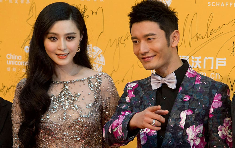 Chinese actress Fan Bingbing, left and Chinese actor Huang Xiaoming arrive for the 4th Beijing International Film Festival.