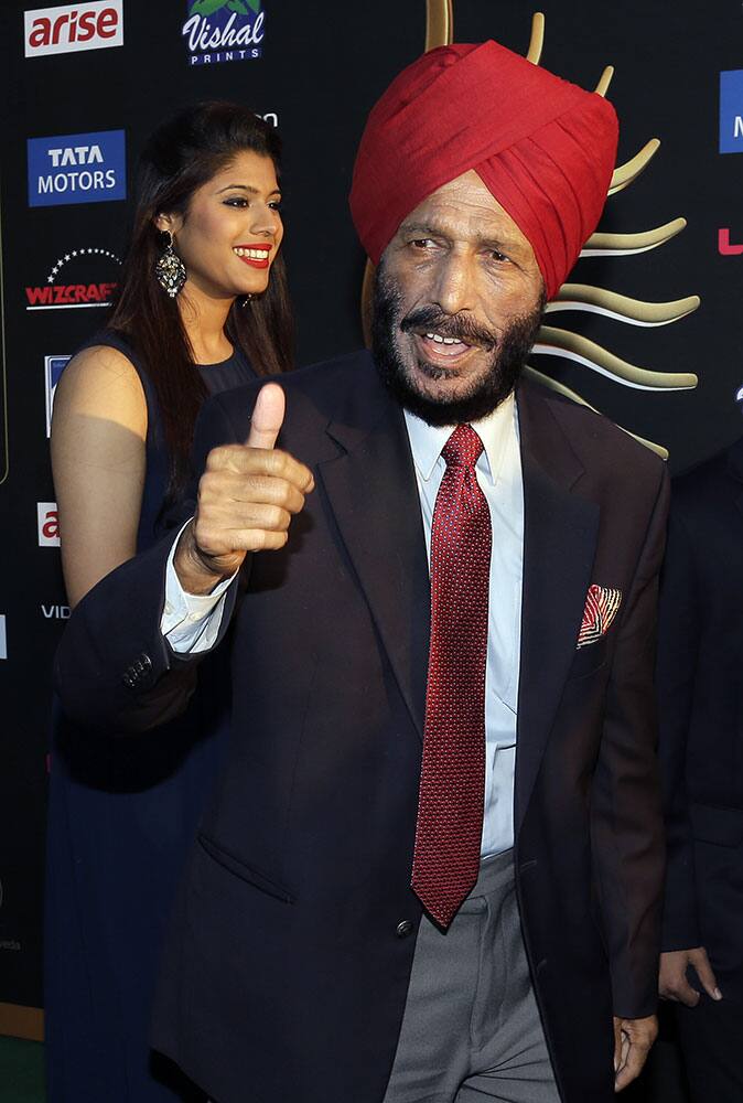 Indian film star Bhaag Milkha Bhaag gives the thumbs up to photographers as he walks the green carpet during arrival for 15th annual International Indian Film Awards.