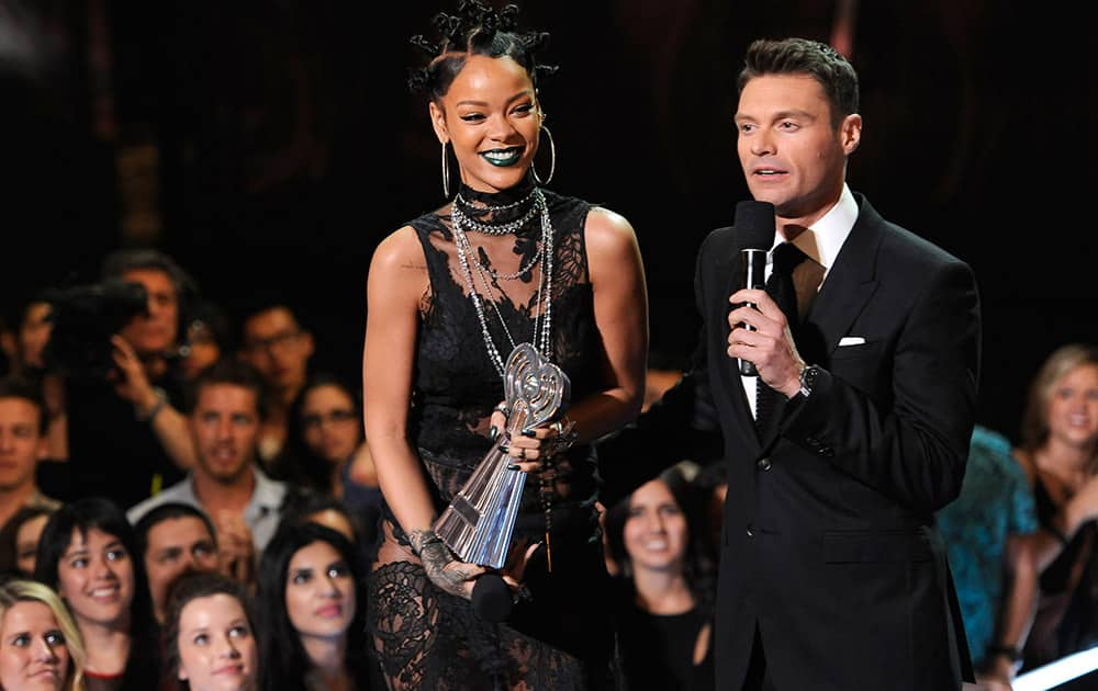 Ryan Seacrest presents Rihanna with the award for artist of the year at the iHeartRadio Music Awards at the Shrine Auditorium in Los Angeles. 