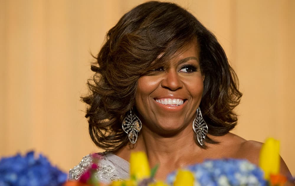 First lady Michelle Obama laughs while listening to President Obama's speech during the White House Correspondents' Association (WHCA) Dinner at the Washington Hilton Hotel.