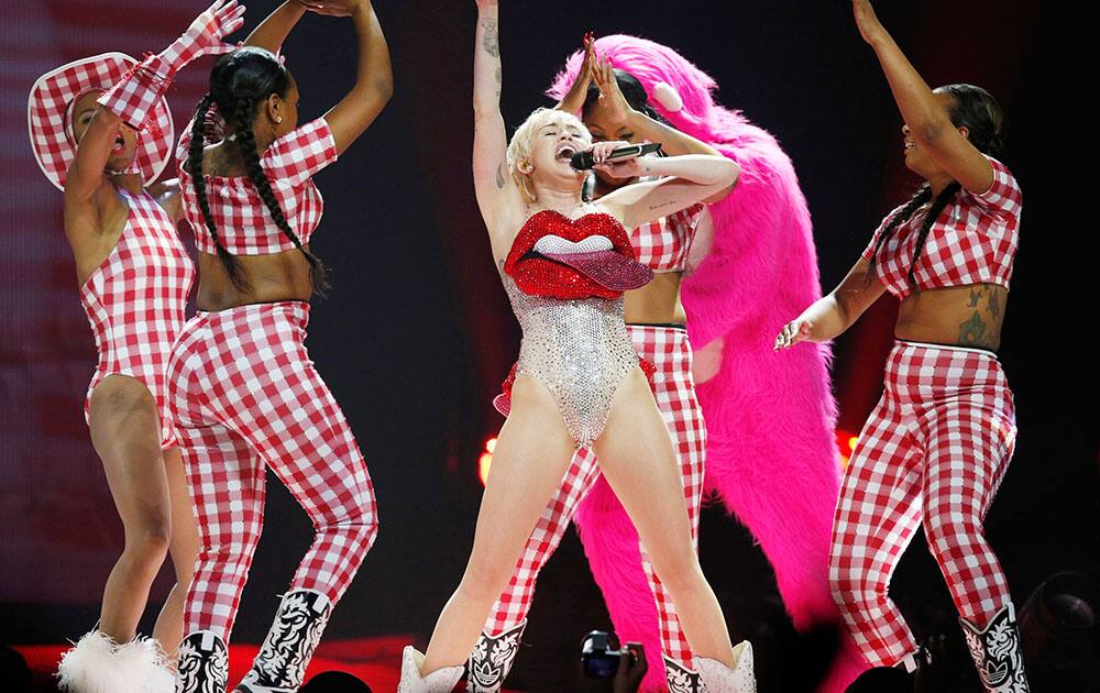 US singer Miley Cyrus, centre performs in concert on the UK leg of her Bangerz tour, at the O2 Arena, London.