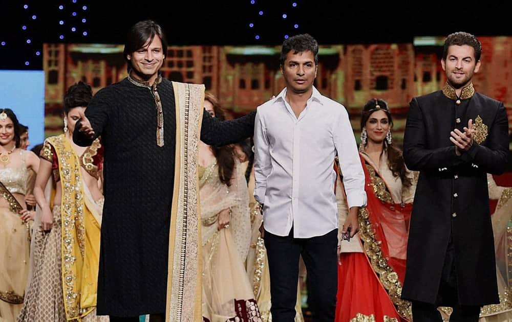 Vivek Oberoi and Neil Nitin Mukesh walk the ramp with designer Vikram Phadnis during a fashion show to support Cancer patients in Mumbai .