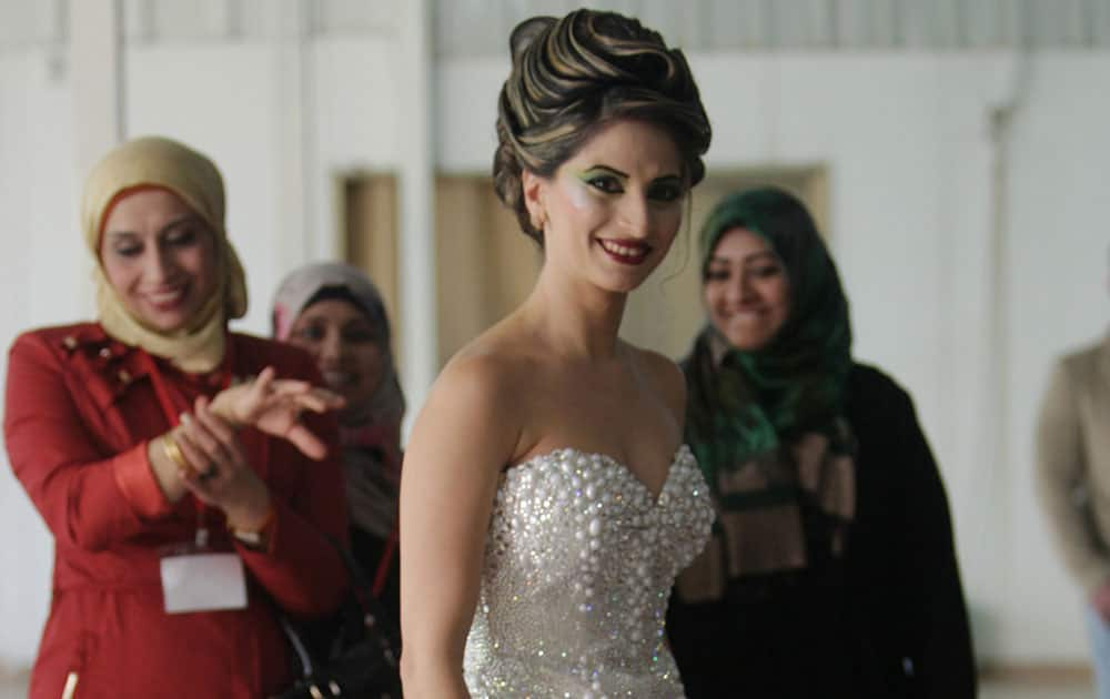 A Palestinian contestant poses for a photo during a festival that features a beauty and hairstyle contest in the West Bank city of Tulkarm.