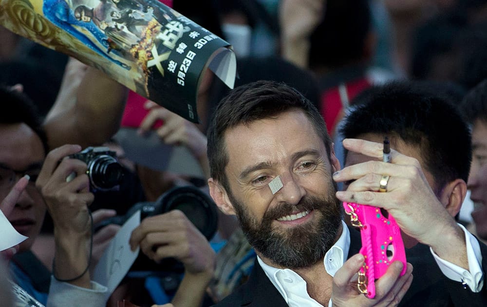 Australian actor Hugh Jackman uses the phone of his fan to take a selfie during the red carpet for his latest movie 'X-Men:Days of Future Past' in Beijing, China.