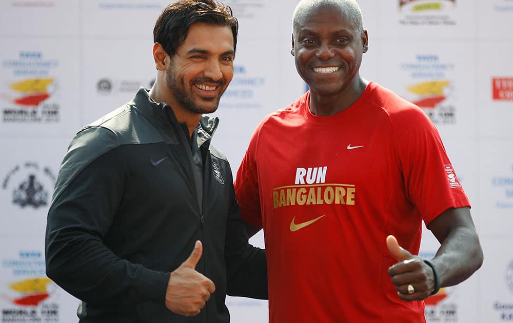 US Olympian Carl Lewis poses with Bollywood actor John Abraham at the TCS World 10K Bangalore 2014 run in Bangalore, India. According to organizers, the event had eight races with total prize money of USD 170,000. 