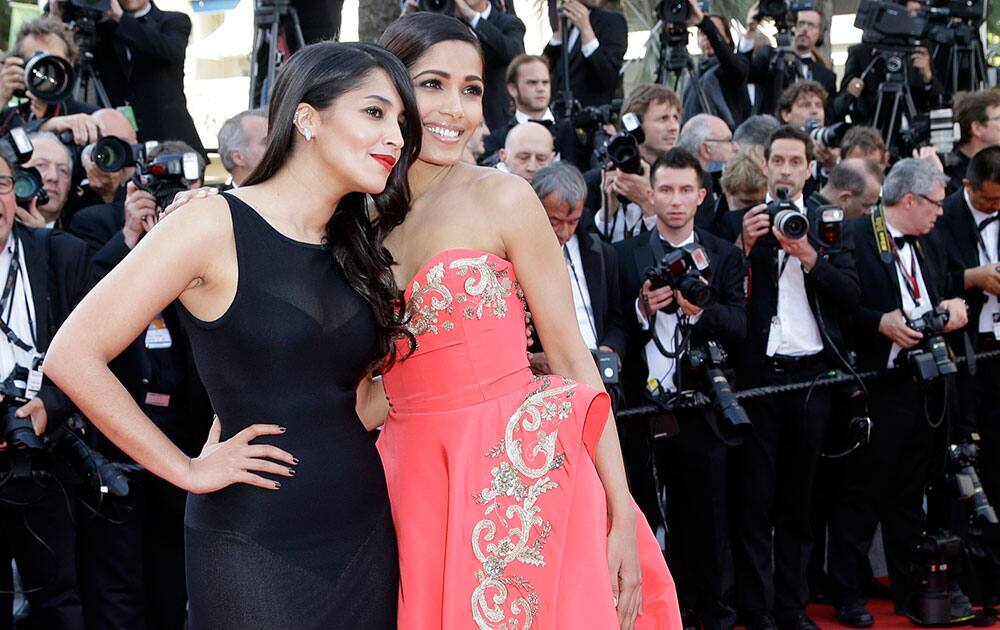 Actors Freida Pinto, right, and Leila Bekhti pose as they arrive for the screening of The Homesman at the 67th international film festival, Cannes, southern France.