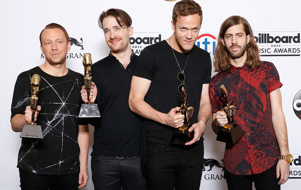 Ben McKee, from left, Daniel Platzman, Dan Reynolds and Wayne Sermon, of the musical group Imagine Dragons, poses in the press room with the award for top rock album for `Night Visions` at the Billboard Music Awards at the MGM Grand Garden Arena.