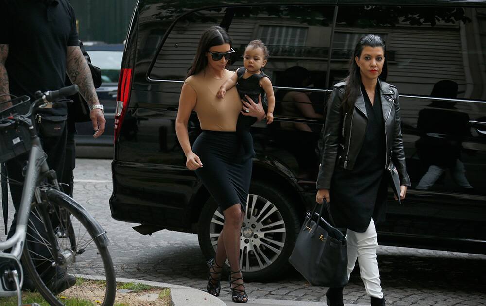 Kim Kardashian, left, arrives at a luxury shop in Paris, France. The gates of the Chateau de Versailles, once the digs of Louis XIV, will be thrown open to Kim Kardashian, Kanye West and their guests for a private evening this week ahead of their marriage. 