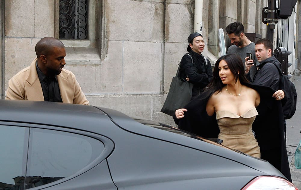 U.S rap artist Kanye West watches Kim Kardashian leaving a luxury shop in Paris. The gates of the Chateau de Versailles, once the digs of Louis XIV, will be thrown open to Kim Kardashian, Kanye West and their guests for a private evening this week ahead of their marria